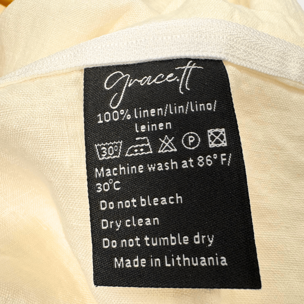 Lininio užvalkalo etiketė su priežiūros ženklais ir informacija – 100 % linas, pagaminta Lietuvoje